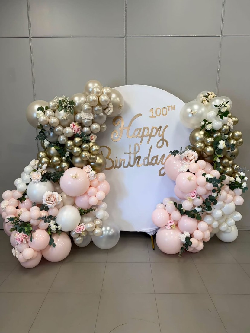 Pink and white balloon display with flowers
