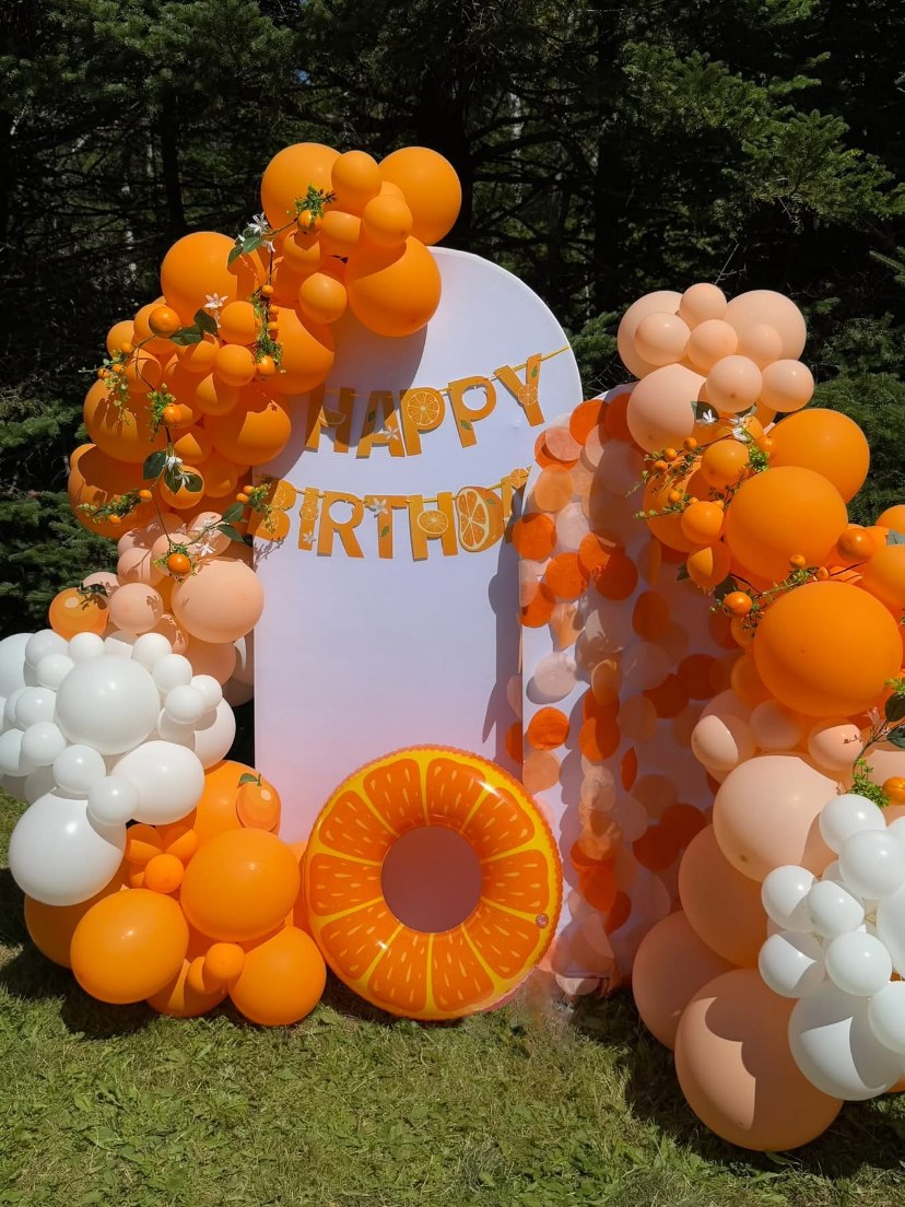 Orange and white citrus-themed birthday balloons