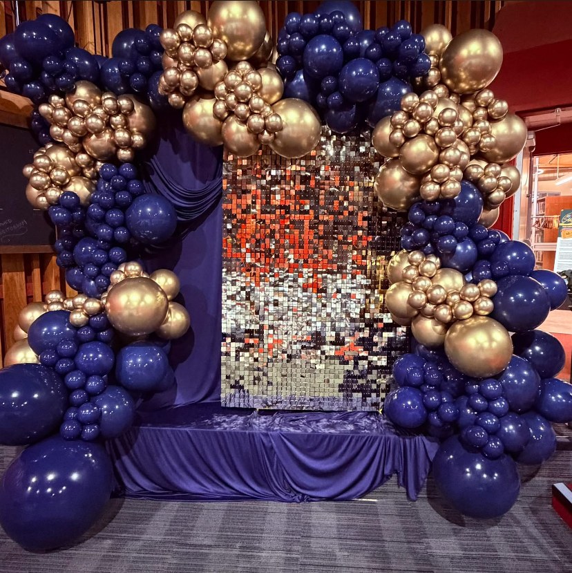 Navy and gold balloon installation surrounding a shimmer wall